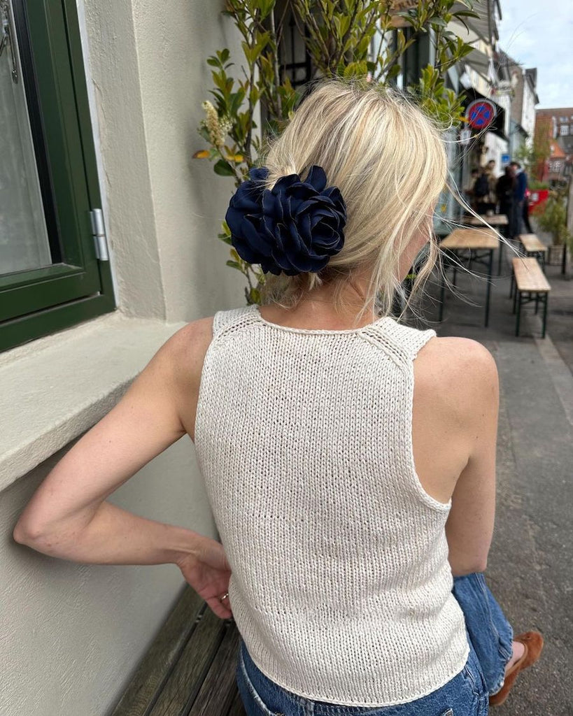 Siddende kvinde iført hvid Alice Top set bagfra