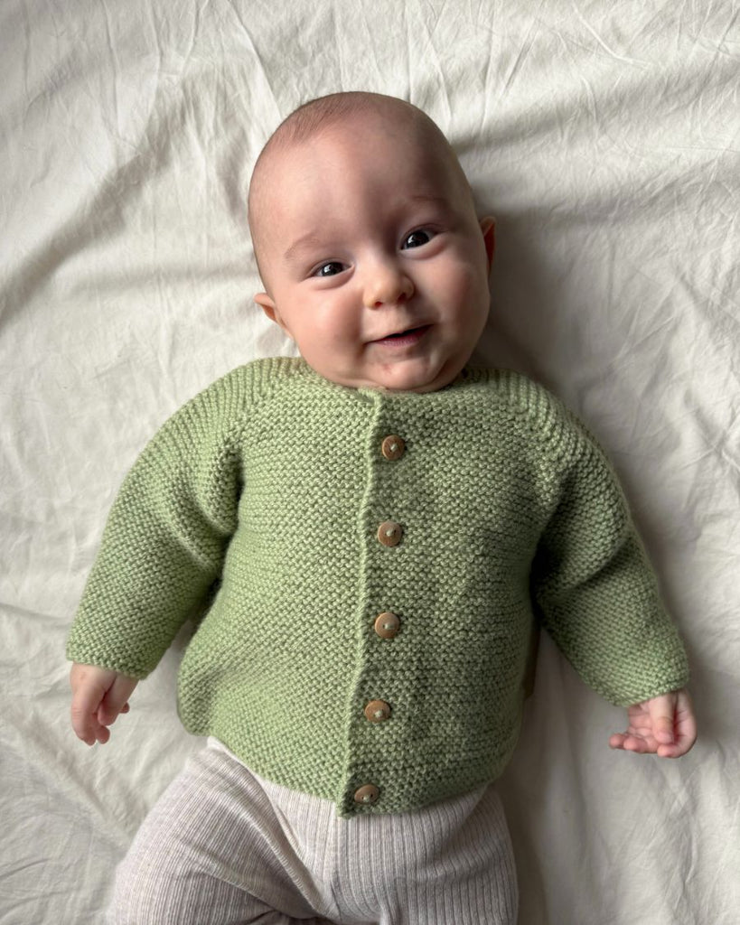 Baby iført grøn Begynderjakken