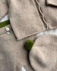 Closeup af beige Cleo Baby Set med grønne detaljer