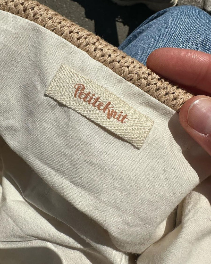 Petiteknit label i biscuit inden i cleo clutch