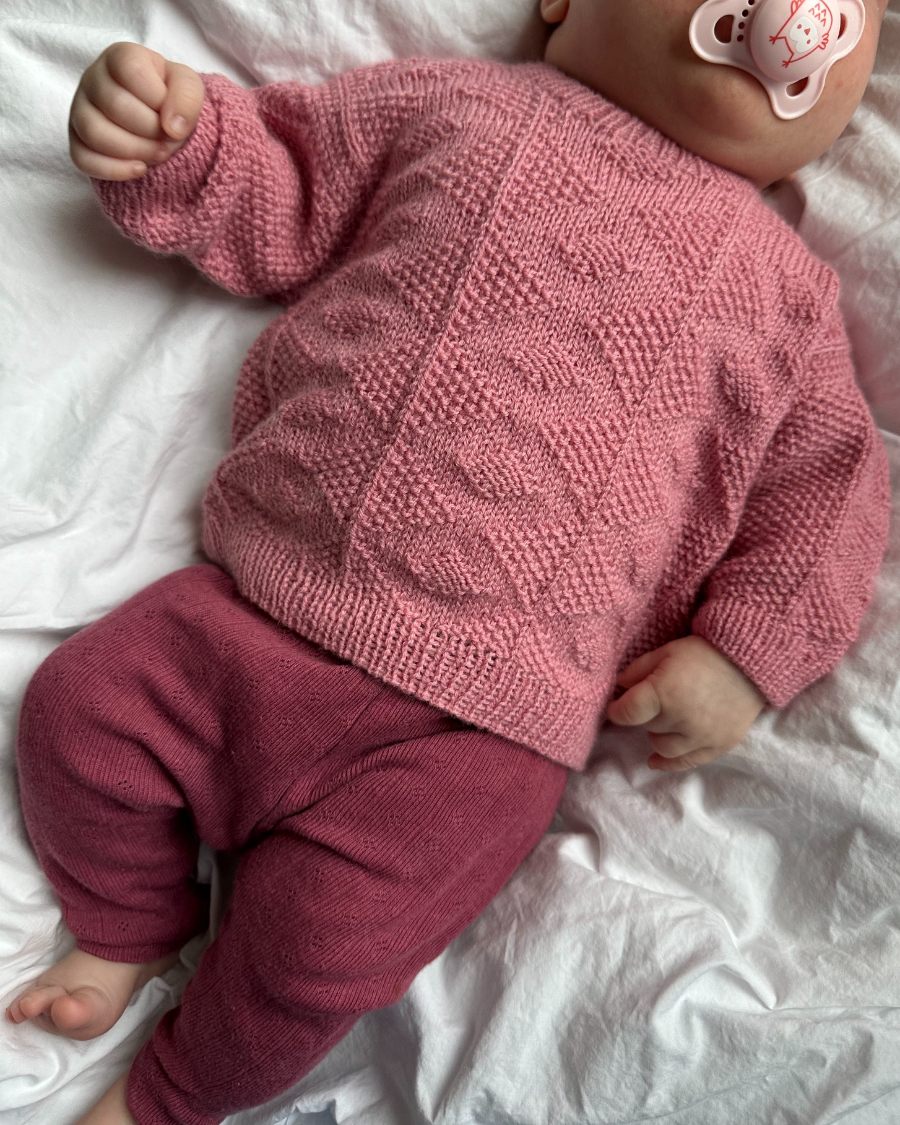 Baby iført lyserød Esther Sweater Baby