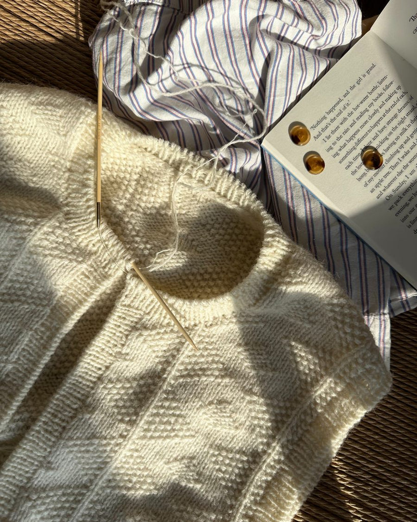 Esther vest med galalit knapper liggende ved siden af