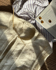 Esther vest med galalit knapper liggende ved siden af