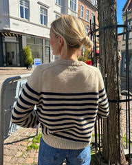 Kvinde iført hvid og blå Lyon Sweater