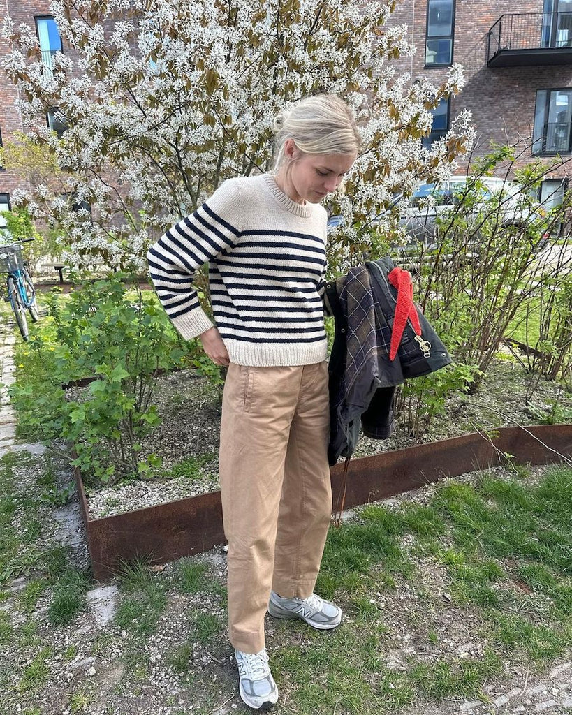 Kvinde iført hvid og blå Lyon Sweater