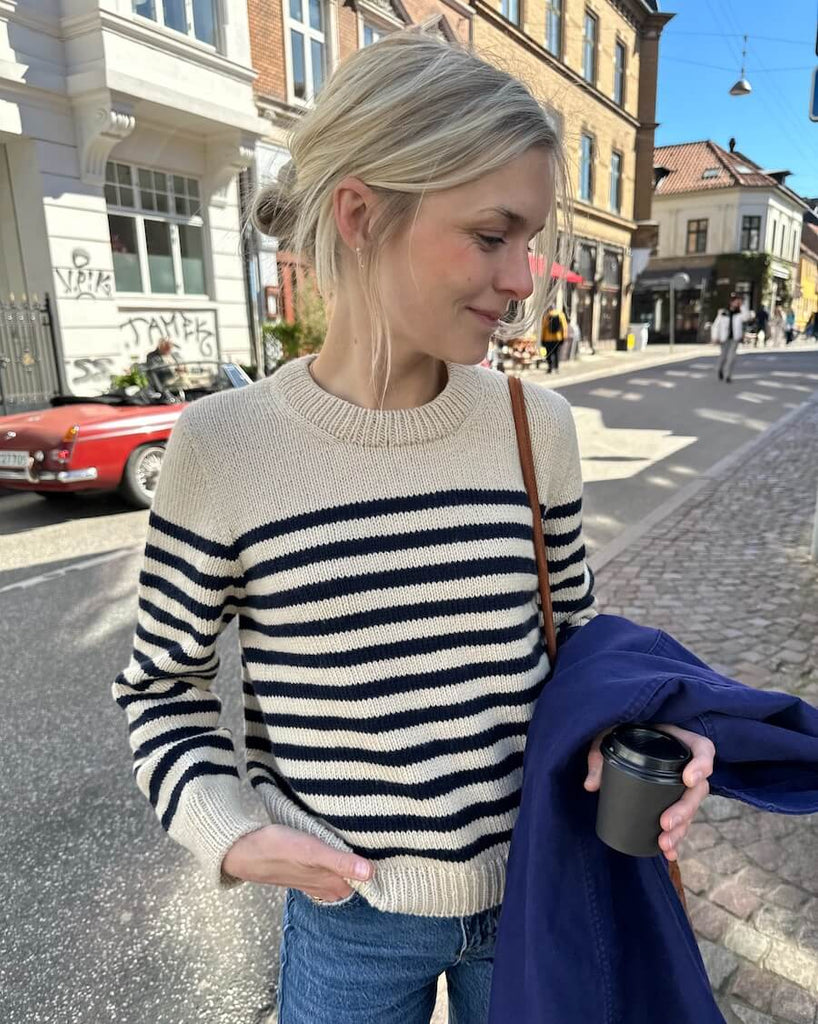 Kvinde iført hvid og blå Lyon Sweater