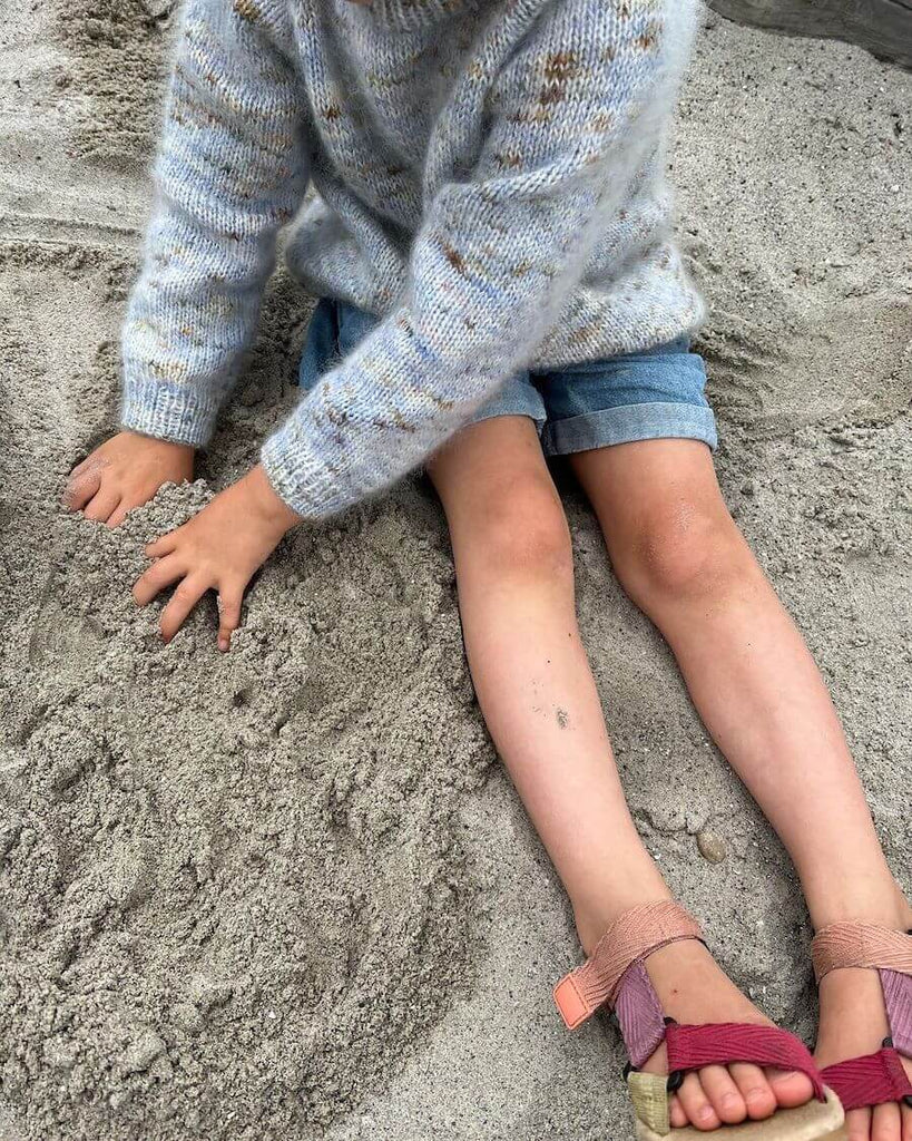 Barn iført nistret lyseblå Monday Sweater Junior