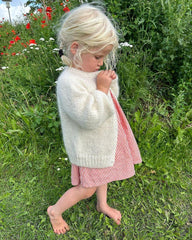 Barn iført hvid Novice Cardigan Mini – Chunky Edition