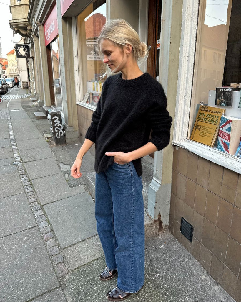 Kvinde iført sort October Sweater