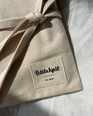 Nærbillede af pindeetui med Petiteknit label på fronten