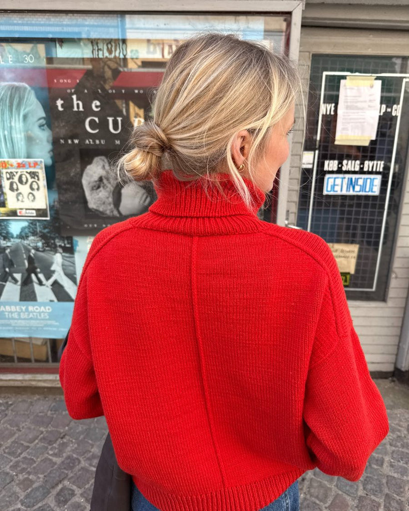 Kvinde med rød Scarlet Sweater set fra ryggen