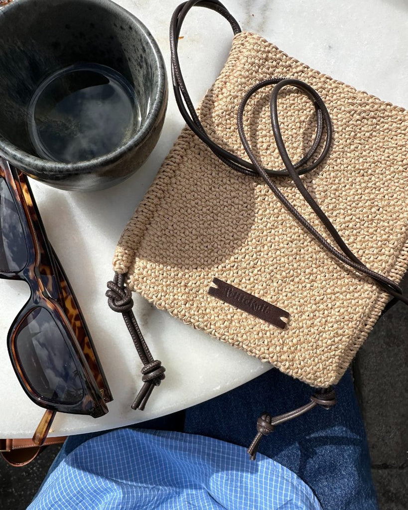 Sienna bag med skindsnører liggende på cafebord