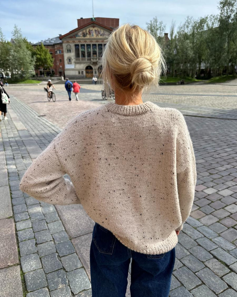 Kvinde iført hvidnistret Sonja Sweater et fra ryggen