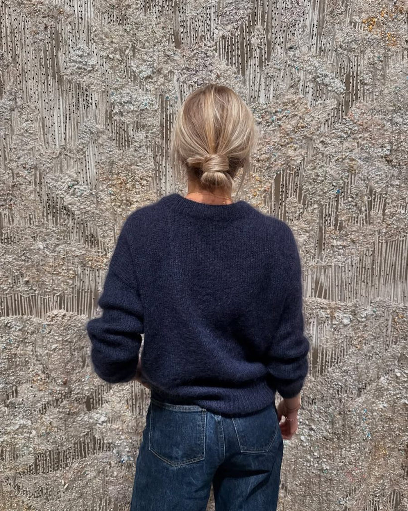 Kvinde iført mørkeblå Stockholm Sweater set fra ryggen