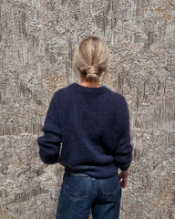 Kvinde iført mørkeblå Stockholm Sweater set fra ryggen