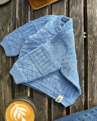 Lyseblå Storm Sweater Baby liggende på bænk