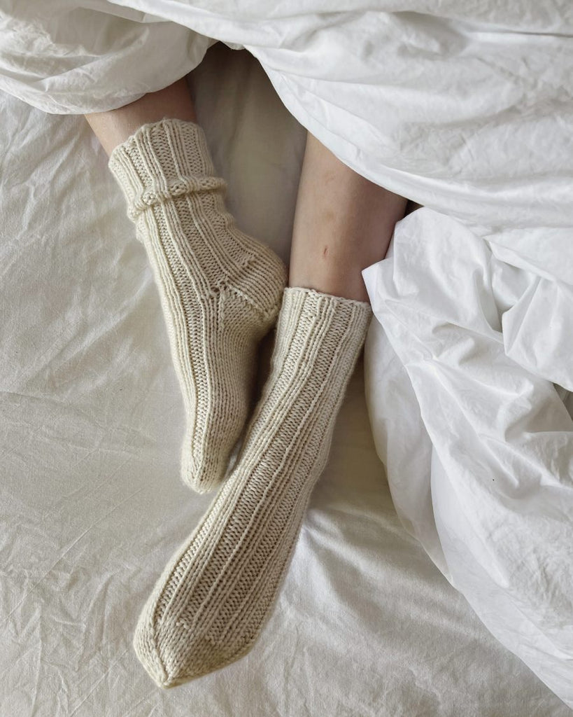 Closeup af fødder med et par hvide Sunday Socks Junior