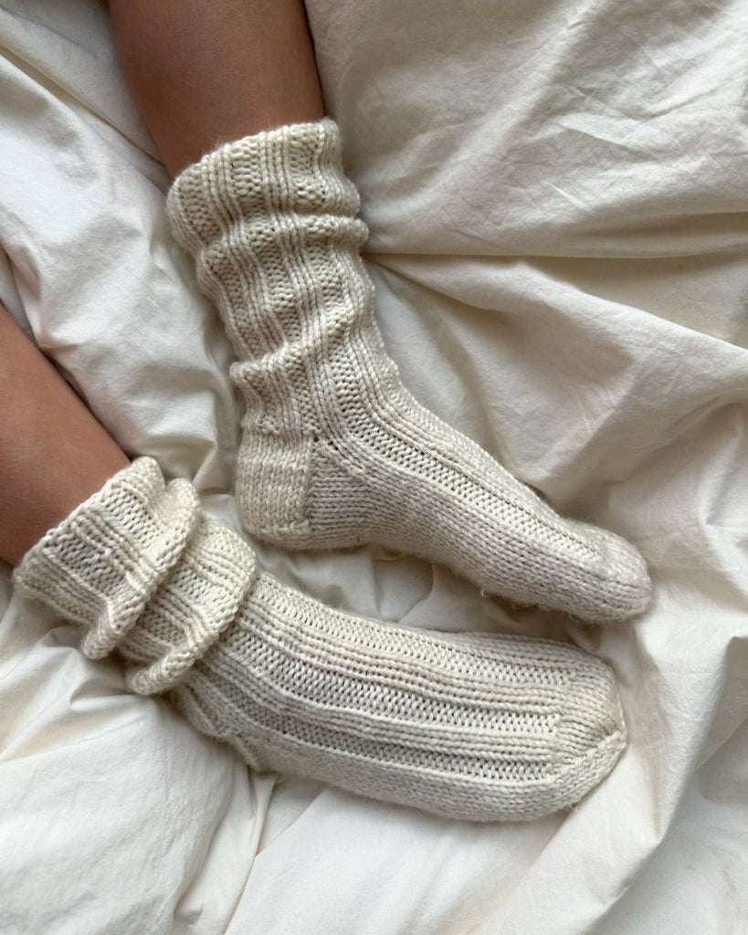 Closeup af fødder med et par hvide Sunday Socks Junior