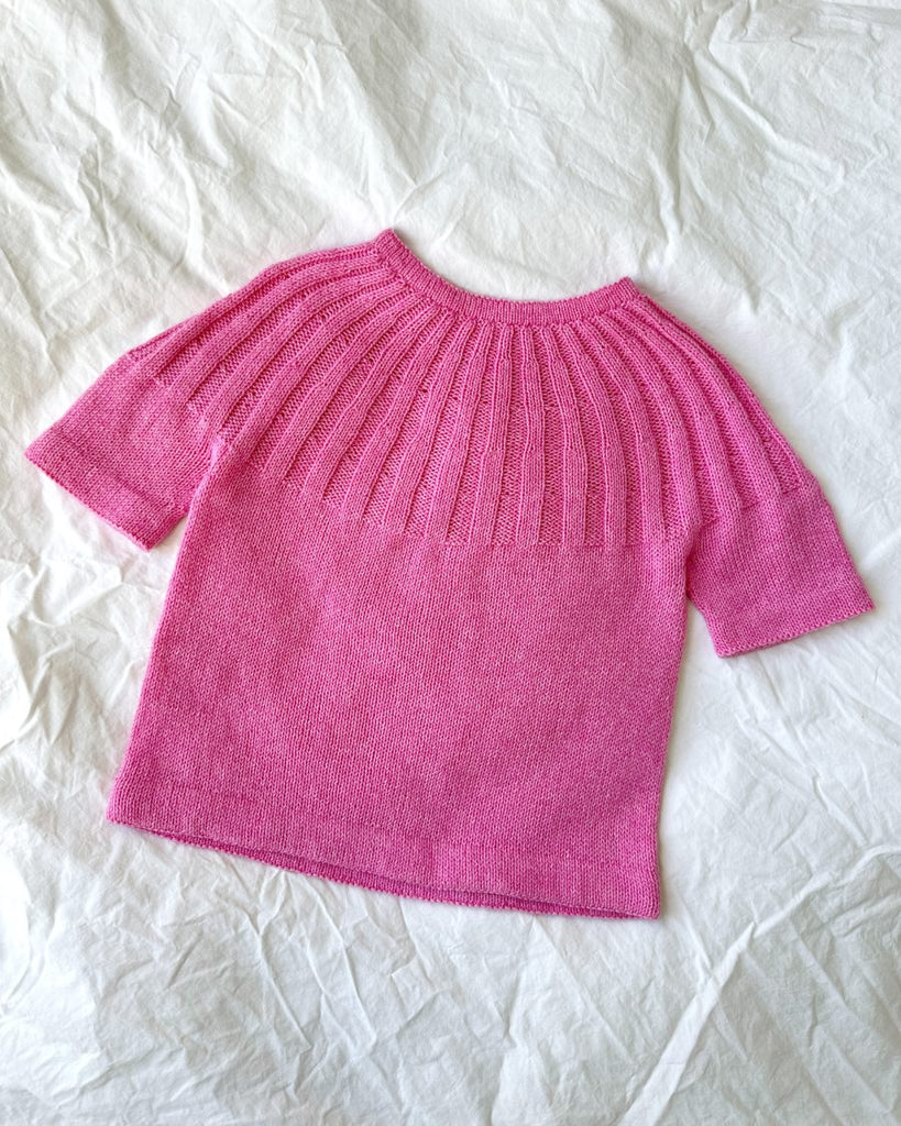 Pink Sunday Tee Junior liggende på dyne