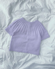 Lilla Sunday Tee Junior liggende på dyne