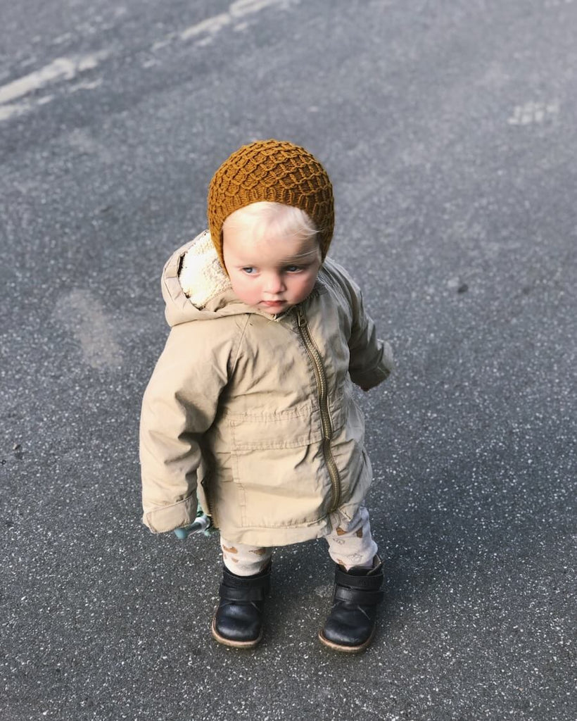 Barn iført okkerfarvet Karens Kyse