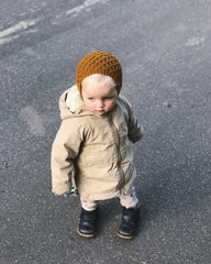 Barn iført okkerfarvet Karens Kyse