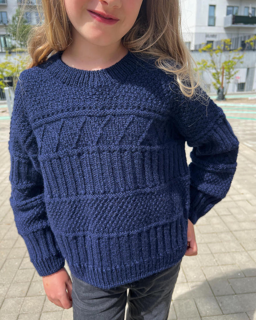 Barn iført mørkeblå Ingrid Sweater Junior
