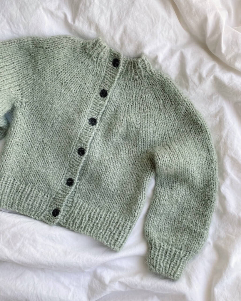 Liggebillde af lysegrøn Novice Cardigan Mini – Chunky Edition