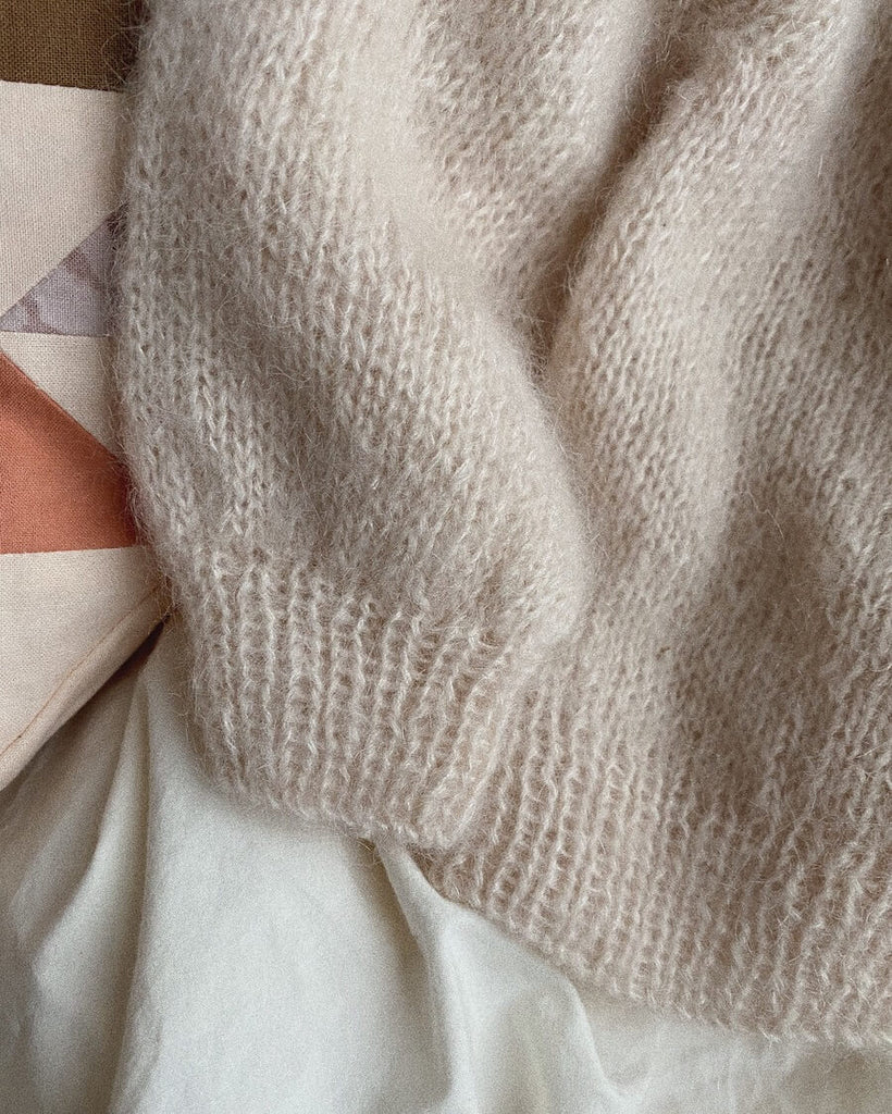 Liggebillede af hvid Novice Cardigan Mini – Mohair Edition