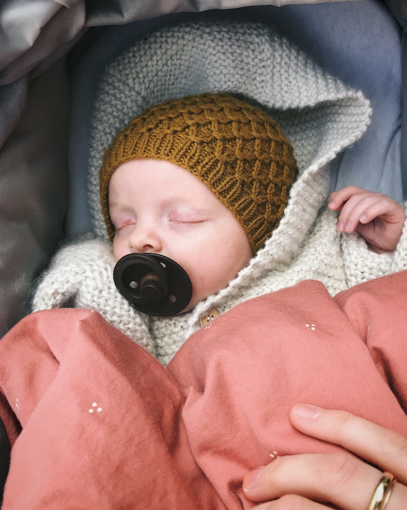 Baby iført okkerfarvet Karens Kyse