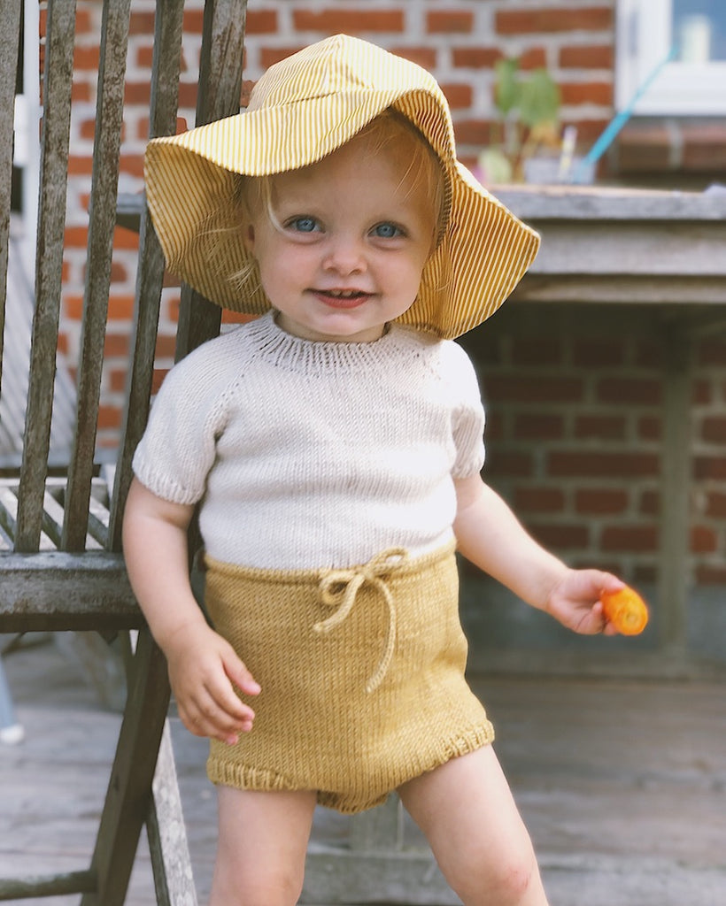 Barn iført hvid og gul Maries Romper