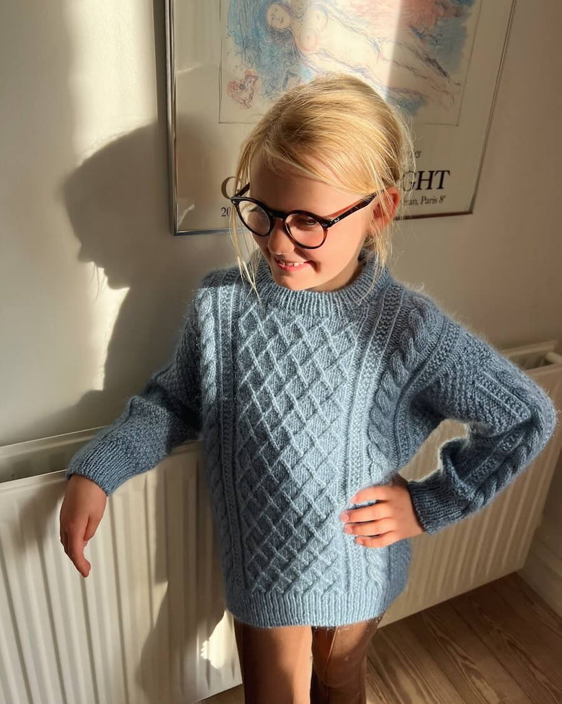 Barn iført blå Moby Sweater Junior
