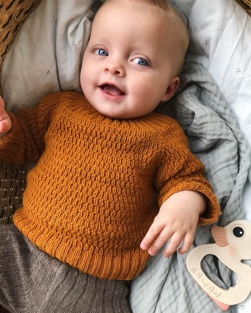 Closeup af liggende barn iført orange Alberts Trøje.