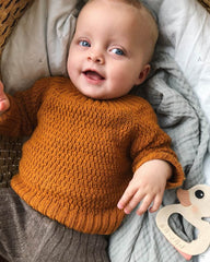 Closeup af liggende barn iført orange Alberts Trøje.