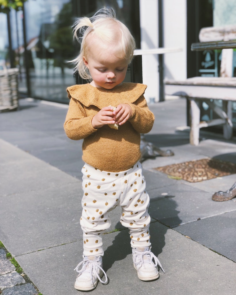 Pige iført gul Almas Flæsebody