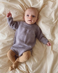 Liggende barn i lilla Ankers Dragt