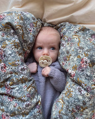 Liggende barn i lilla Ankers Dragt