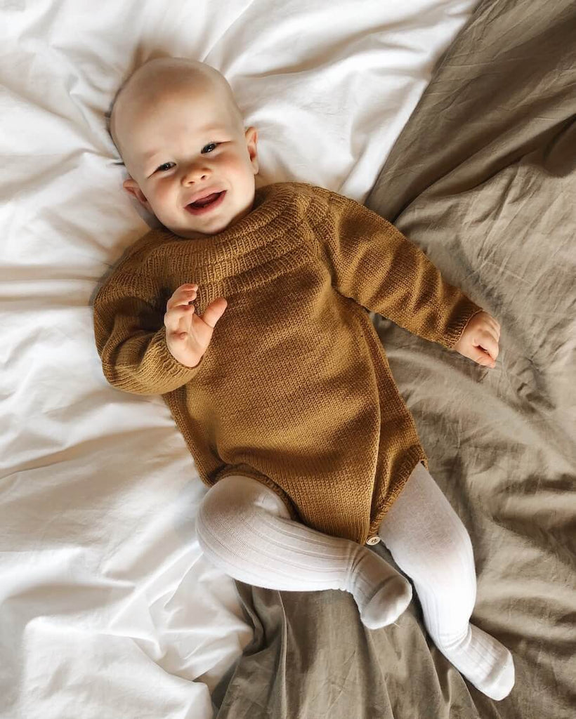 Liggende barn i brun Ankers Dragt