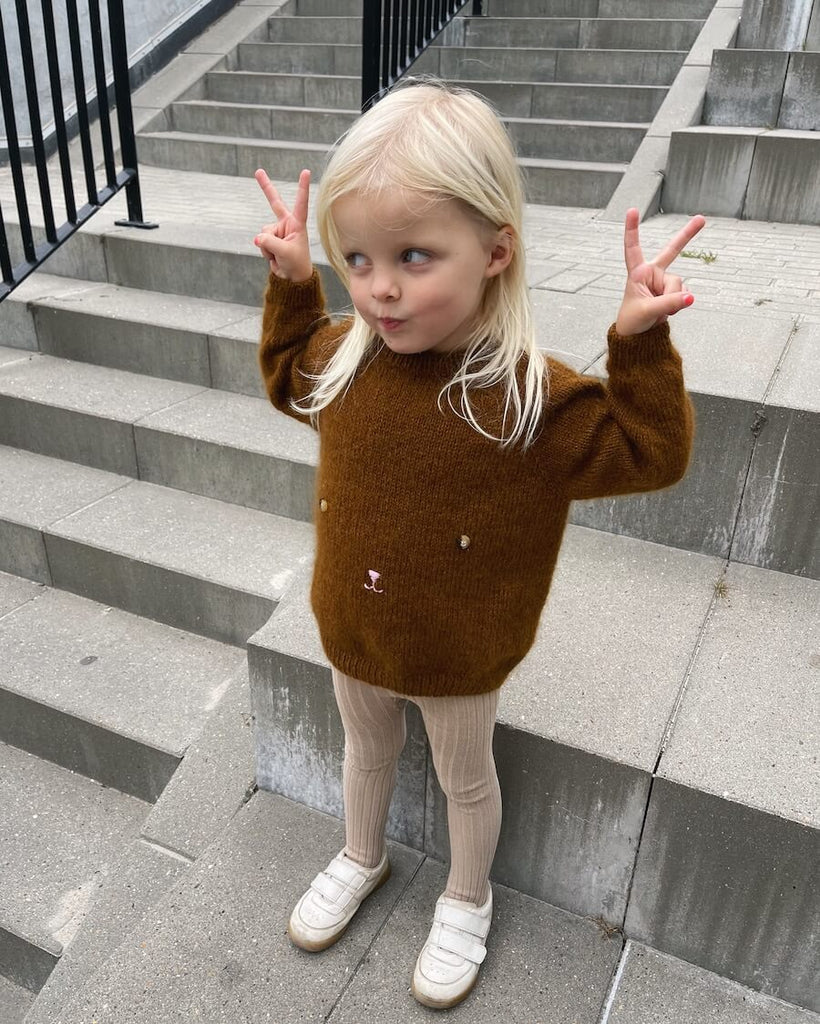 Barn iført brun Bamsesweater