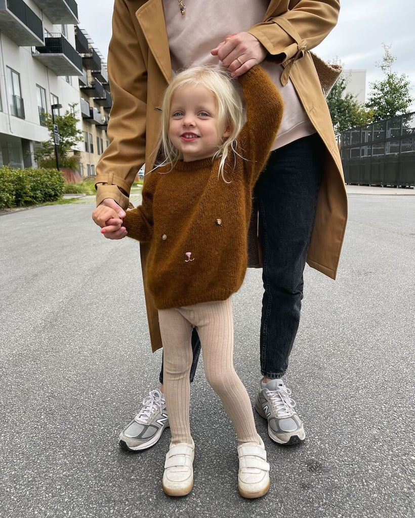 Barn iført brun Bamsesweater