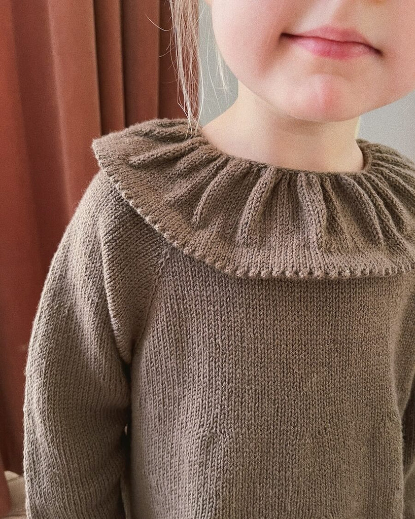 Closeup af barn iført brun Dagmars Kjole