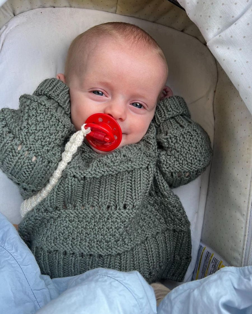Baby iført grønlig Ingrid Sweater Baby