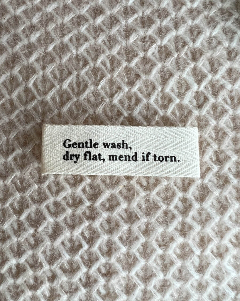 "Gentle wash, dry flat, mend if torn." label