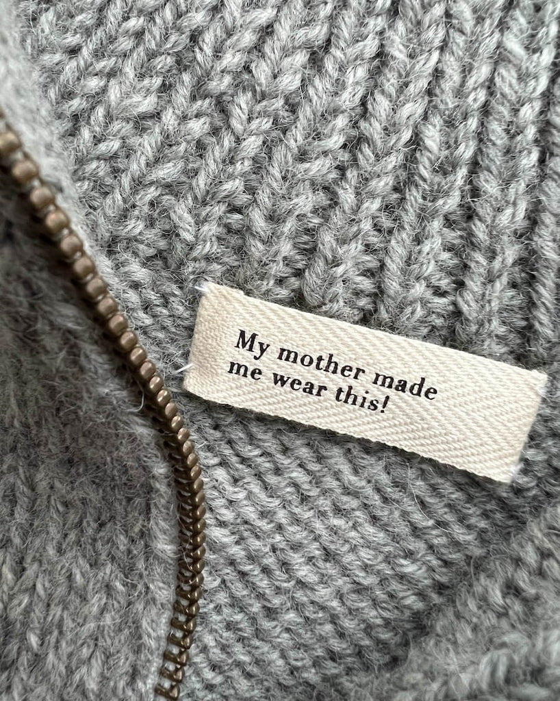 Nærbillede af label med teksten "My mother made me wear this!".
