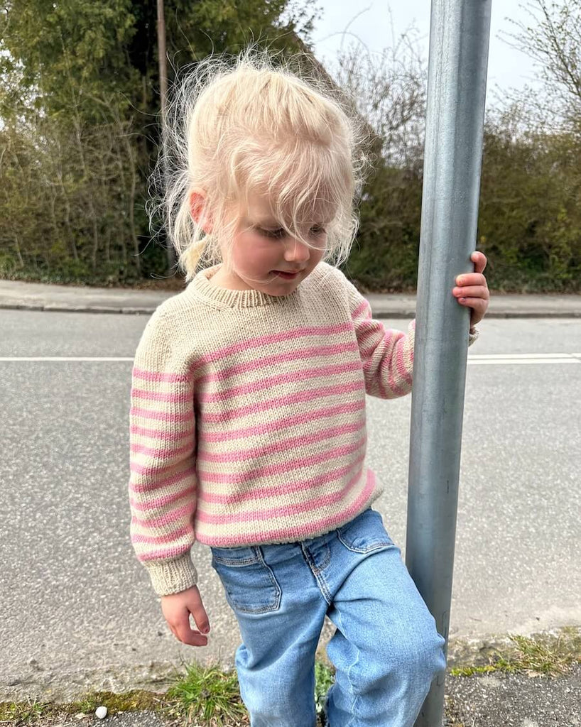 Barn iført hvid og lyserød Lyon Sweater Junior
