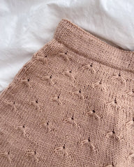 Detaljebillede af lyserød Mælkebøttenederdel