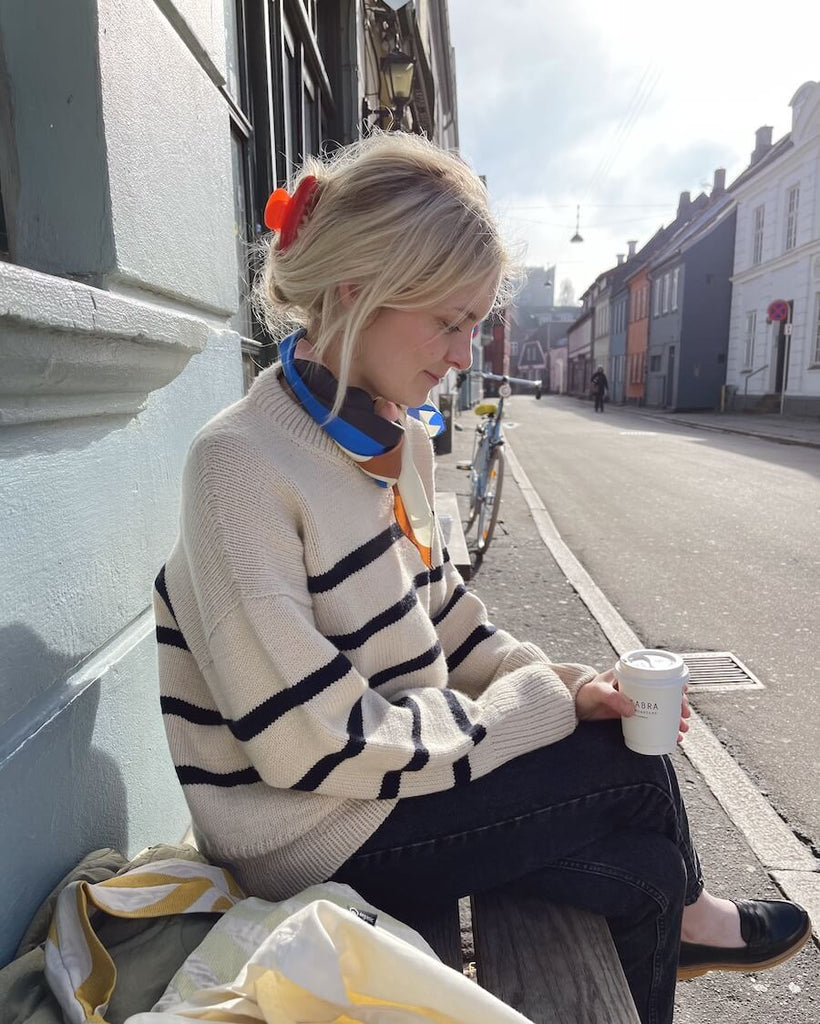 Kvinde iført hvid og blå Marseille Sweater