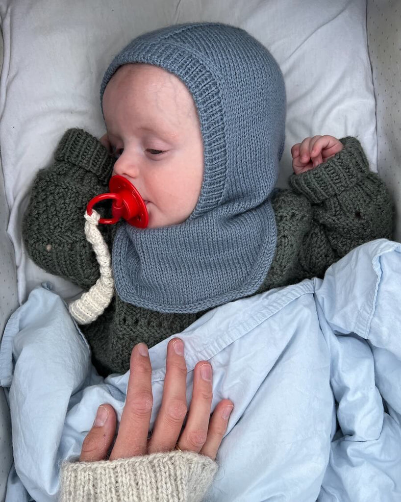 Baby iført blå Monday Balaclava