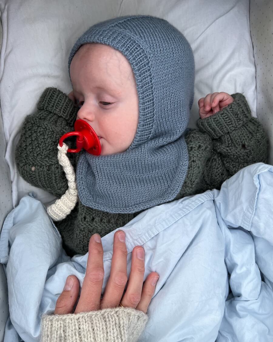 Baby iført blå Monday Balaclava
