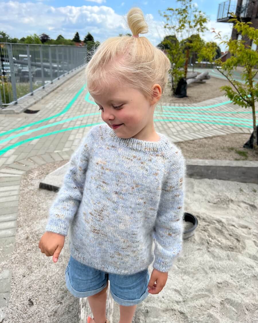 Barn iført nistret lyseblå Monday Sweater Junior